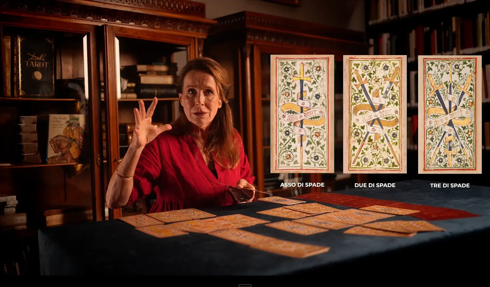 Marianne Costa spiega le carte mentre accanto a lei compaiono in grafica asso, due e tre di spade del Mazzo Colleoni